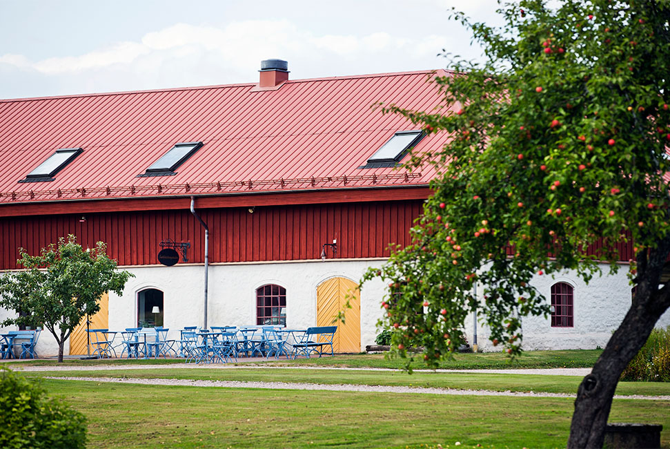 En lada med restaurang och uteservering i trädgårdsmiljö
