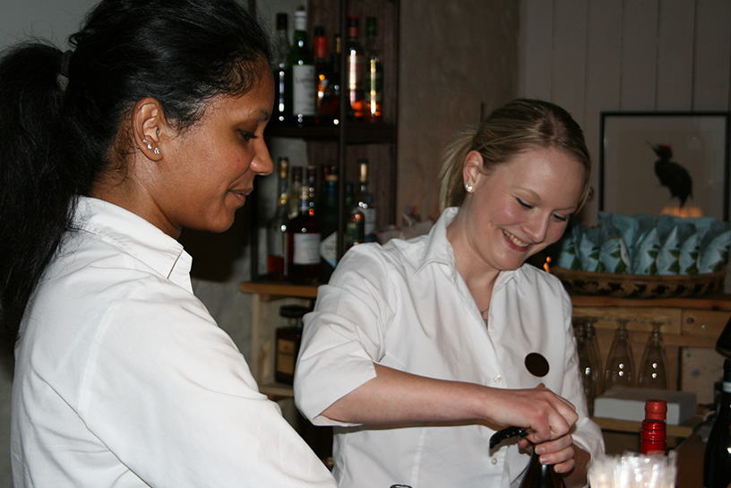 Glada servitriser jobbar i baren